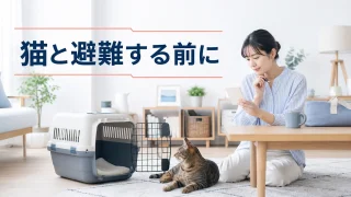 猫と普段のキャリーを前に避難先のメモを確かめる室内