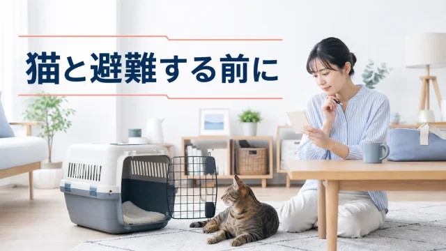 猫と普段のキャリーを前に避難先のメモを確かめる室内